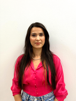 Student President Rahela smiling with pink top on